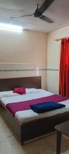 a bedroom with a large bed with red curtains at Hotel Blue Moon Old Station Bhubaneswar in Jāmb
