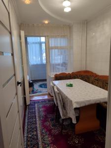 a dining room with a table and chairs and a door at Квартира in Cholpon-Ata