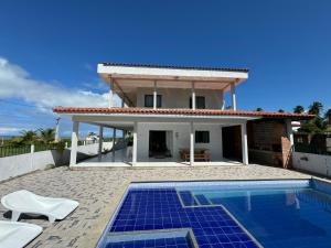 eine Villa mit Swimmingpool und ein Haus in der Unterkunft Casa Vista Mar Maragogi- Pé na areia in Peroba