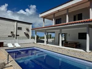eine Villa mit einem Swimmingpool vor einem Haus in der Unterkunft Casa Vista Mar Maragogi- Pé na areia in Peroba