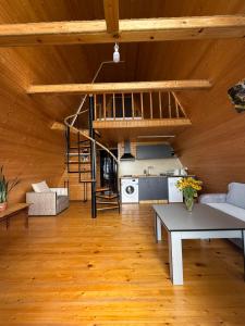a living room with a table and a loft at Little Wood Cabin in Gant'iadi