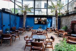 a patio with tables and chairs and palm trees at Unique Luxury Suite in Shkodër