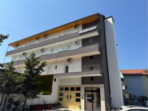a tall white building with a balcony at Hotel Kaloshi in Tirana
