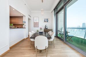 a dining room with a table and chairs at Elegant 4BR High-Rise Overlooking Burj Khalifa & Fountains in Dubai