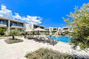 un complejo con piscina con sillas y sombrillas en Olea Valley A24 apartment, en Nikiti