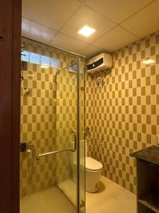 a bathroom with a glass shower with a toilet at Temple Stay - Diem Phung Pagoda 