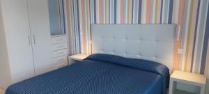 a small bedroom with a blue bed and a dresser at Appartamento Espero in Gabicce Mare
