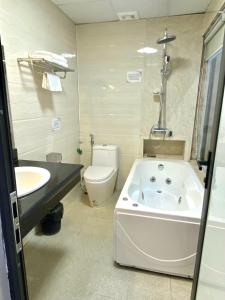 a bathroom with a tub and a toilet and a sink at NASA Hotel in Bồ Sơn