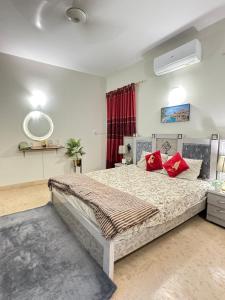 a bedroom with a large bed with red pillows at Aroma Palace Dha in Karachi