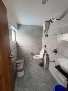 a bathroom with a toilet and a sink at Hotel Skyland in Ahmedabad +19 photos