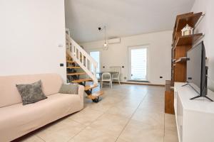 Una sala de estar con un sofá y un televisor en Tacos House, en Empoli