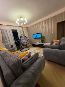 a living room with couches and a flat screen tv at C7 Haven Artesano in Nairobi