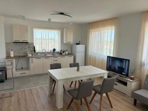 a kitchen with a table and chairs and a television at Vila Nikalas in Tyulenovo