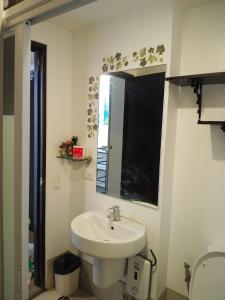 a white bathroom with a sink and a mirror at Midnight Cove Abreeza Place T1-1921 in Davao City
