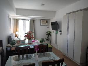 a room with a desk and a table with chairs at Midnight Cove Abreeza Place T1-1921 in Davao City