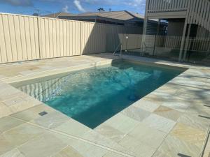a swimming pool in the middle of a yard at Shades Of Summer 50 Park Street in Evans Head