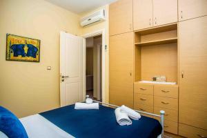 sypialnia z niebieskim łóżkiem i szafą w obiekcie Maniata Holiday Apartments w mieście Andipáta Erísou
