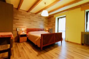 1 dormitorio con 1 cama y pared de madera en Albergo Speranza en Asiago