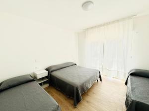 een slaapkamer met twee bedden en een raam bij Verga - Dietro Piazza Mazzini - Immobil Relax in Lido di Jesolo