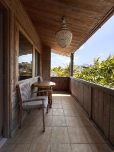 a porch with a table and a chair on a balcony at Iru Maldives in Thulusdhoo