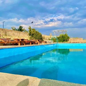 a blue swimming pool with a water slide at Lernarot Guest House in Lernarot