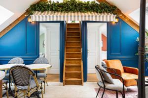 a room with blue walls and tables and chairs at Le petit Paris in Villejuif