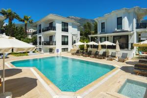 a large swimming pool in front of a house at Marla Suite Fethiye in Fethiye