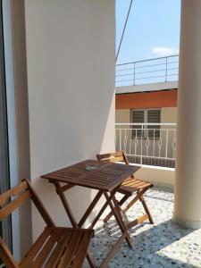 a wooden table and a chair on a balcony at Natasa's Appartment in Kalamata in Kalamata