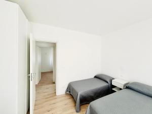 a white room with two beds and a room with a hallway at Verga - 100 m da Piazza Mazzini - Immobil Relax in Lido di Jesolo