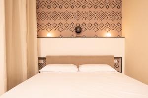 a bedroom with a bed and a wall with at Iglesias Centro Apartments In Sardinia in Iglesias