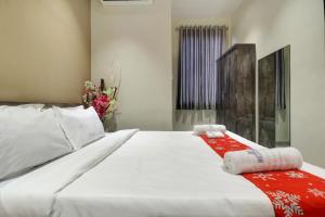 a bedroom with a large white bed with a red blanket at Hotel Royal Inn Nerul in Navi Mumbai