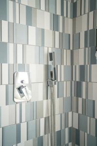 a bathroom with a shower with blue and white tiles at Iglesias Centro Apartments In Sardinia in Iglesias