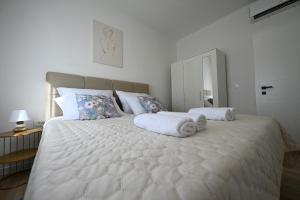 a bedroom with a large white bed with towels on it at Villa Zara Blu with pool in Briševo +29 photos