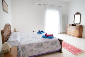 a bedroom with a bed and a dresser and a mirror at Casa Relax in Montalbano Ionico