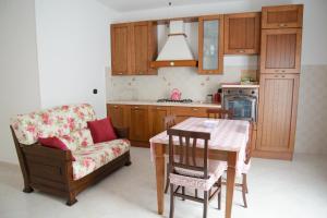 a kitchen with a table and a chair and a couch at Casa Relax in Montalbano Jonico