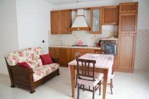 a kitchen with a table and a chair and a couch at Casa Relax in Montalbano Ionico