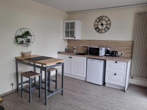 a kitchen with white cabinets and a table and a microwave at Al Copette in Durbuy
