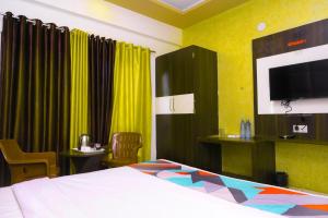a hotel room with a bed and a tv at MANGAL RESIDENCY Mountain View- A Luxury Boutique Business Hotel in Bedla