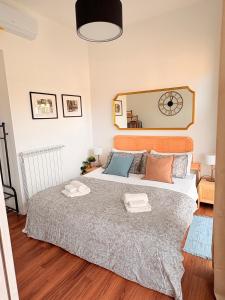 a bedroom with a large bed with a clock on the wall at StayHub-RHO in Rho
