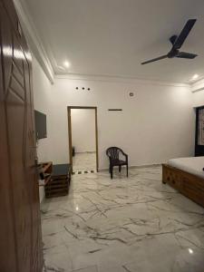 a room with a ceiling fan and a chair at LunaBloom Stays in Maraiyūr +55 photos
