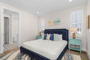 una camera bianca con un letto e una testiera blu di 209 Seabreeze Escape- NEW Spacious 5-Bedroom Pool Home home a Fort Myers Beach