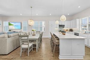 una cucina e un soggiorno con tavolo e sedie di 209 Seabreeze Escape- NEW Spacious 5-Bedroom Pool Home home a Fort Myers Beach