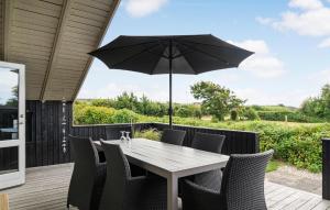 VestervigにあるCozy Home In Vestervig With Wifiのテーブルと椅子、パラソル付きのデッキ +10枚の写真