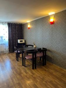 a dining room with tables and chairs and a wall at Простора та стильна 2 кімнатна в центрі Черкас на бульварі Шевченко з панорамним видом та СмартТВ! Дві окремі охайні спальні з кондиціонерами,поруч парковка з охороною in Cherkasy
