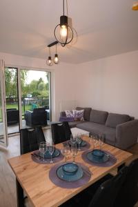 una sala da pranzo con un tavolo con bicchieri da vino sopra di Lawendowy Apartament Kąty a Kąty Rybackie