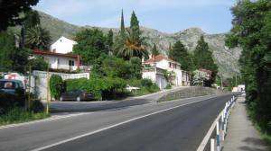 an empty street with houses and a mountain at Perun Guest House in Mlini