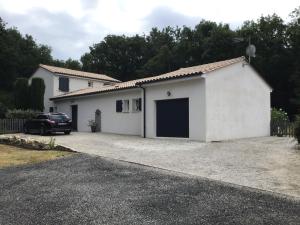 a white garage with a car parked in front of it at Havre de paix avec 2 chambres et salle de bain in Claix