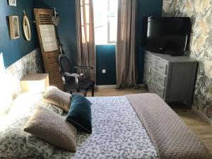 a bedroom with a bed with a tv on a dresser at Havre de paix avec 2 chambres et salle de bain in Claix