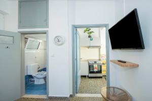 a bathroom with a toilet and a tv on a wall at Mandilara Minimal Apartment in Rhodes Town