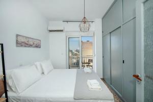 a bedroom with a white bed and a window at Mandilara Minimal Apartment in Rhodes Town